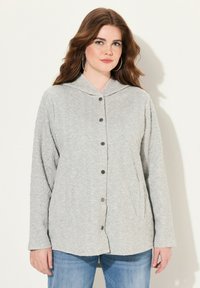 Světle šedá košile na knoflíky s kapucí, s texturovaným diamantovým vzorem, dlouhými rukávy a stříbrnými knoflíkovými akcenty. Ležérní design.