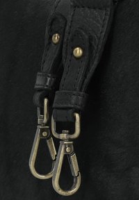 Cinturino in pelle nera con due moschettoni in metallo. I moschettoni hanno una finitura bronzo spazzolato e sono attaccati con rivetti per maggiore durata.