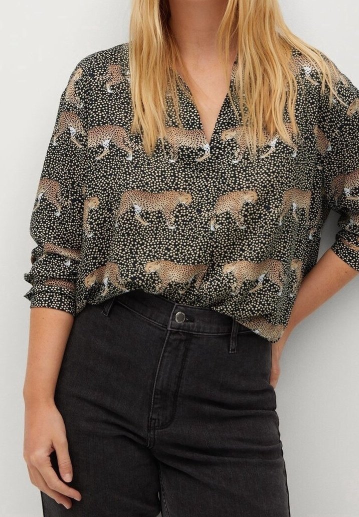 Schwarz-weiße Bluse mit Leopardenmuster, lockerer Schnitt, Knopfleiste und aufgerollten Ärmeln. Weicher, strukturierter Stoff.