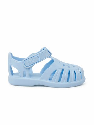Light blue plastic sandals with open design, rounded toe, and adjustable strap. Features ventilation slots and a textured sole.
