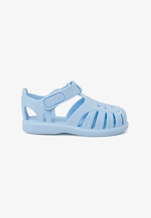 Light blue plastic sandals with open design, rounded toe, and adjustable strap. Features ventilation slots and a textured sole.