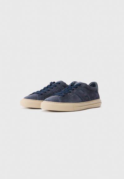 Pair of navy blue suede sneakers with dark blue laces and beige rubber soles on a light gray background.