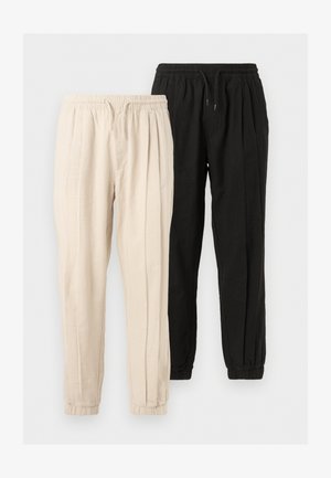 Two pairs of casual cotton pants with elastic waistbands and cuffs, one in beige and one in black, shown side by side on a plain background.