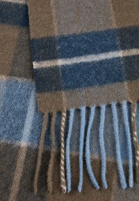 Couverture en laine dans des nuances de marron et de bleu avec un motif à carreaux. Présente des bords frangés et une surface douce et texturée.