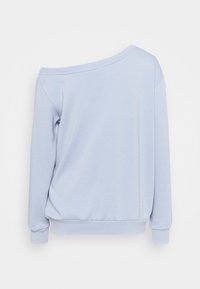 Sudadera azul claro con un diseño de hombros descubiertos, puños acanalados y un corte relajado, confeccionada en un suave tejido texturizado.