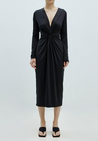 Schwarzes langärmliges Kleid mit tiefem V-Ausschnitt, das in der Mitte mit Raffungen versehen ist und eine gerade Midi-Länge hat. Glatte, dehnbare Stoffqualität.