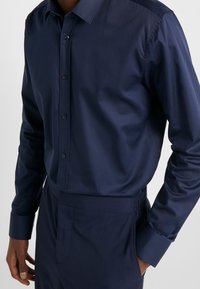 Marineblauw overhemd met knopen, gemaakt van soepele stof met een slim fit, met lange mouwen en een klassieke kraag.