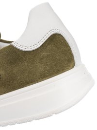 Primo piano del tallone di una sneaker che mostra la tomaia in camoscio verde oliva e pelle bianca con suola in gomma bianca.