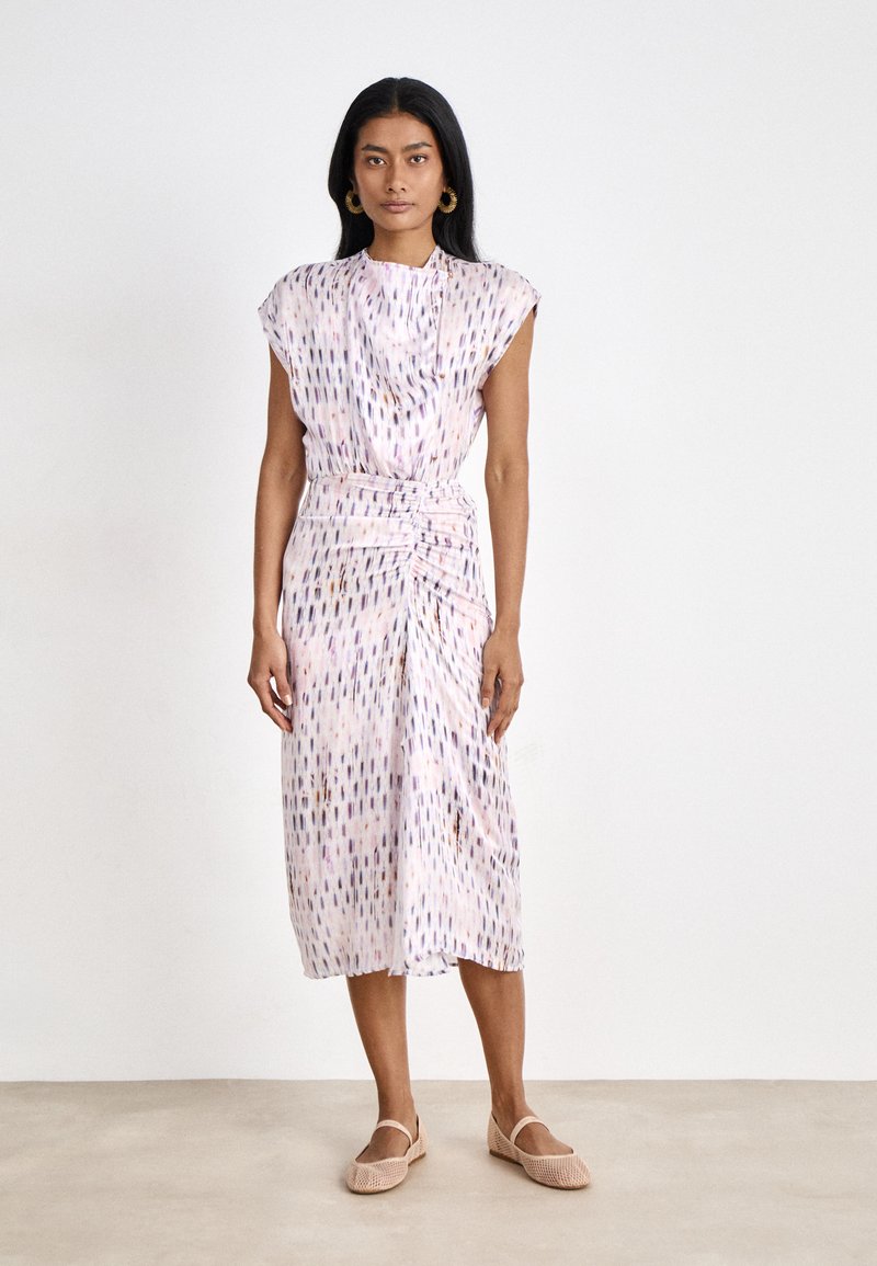 Midi dress in lightweight fabric, featuring a pink base with a colorful drop pattern, gathered waist, and cap sleeves. Paired with beige shoes.