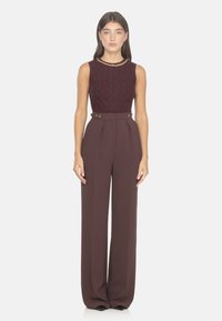 Conjunto de dos piezas burdeos que incluye una blusa sin mangas texturizada con un escote acentuado en dorado y pantalones de pierna ancha de talle alto con botones.