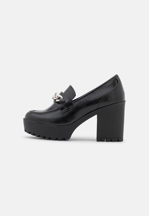 Sort chunky platformsko med hæl og loafer-design, sølvkædedetalje på overlæderet, glat finish og tekstureret lurvet sål.