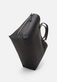 Svart läder tote-väska med en texturerad yta, dragkedjeförslutning och två kraftiga handtag. Har en strukturerad form och släta accenter.