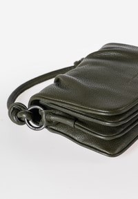 Borsa a tracolla in pelle verde oliva con superficie texture, design piegato e dettagli in metallo nero. Dotata di una tracolla removibile.