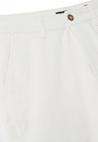 Weiße Baumwollhosen mit einem Knopfverschluss, Fronttaschen und Gürtelschlaufen. Glatte Textur mit minimaler Naht und ohne sichtbare Muster.