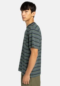 Striped short-sleeve t-shirt in navy blue, featuring horizontal lines in green, yellow, and white. Regular fit with a round neckline.