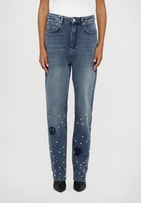 Hoge taille blauwe denim jeans met een rechte pijp, voorzien van geborduurde vrede- en hartsymbolen, en versierd met witte nepparels.