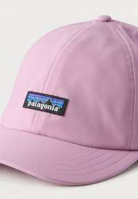 Ανοιχτό μοβ καπέλο μπέιζμπολ με ραμμένα πάνελ, κυρτή γείσο και μαύρο ορθογώνιο λογότυπο Patagonia στην πρόσοψη.