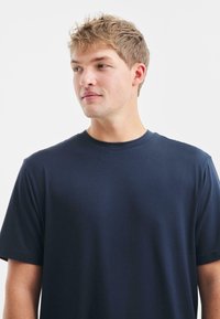 T-shirt navy blue a maniche corte con scollatura rotonda. Tessuto liscio e design semplice, caratterizzato da una vestibilità comoda e senza loghi visibili.