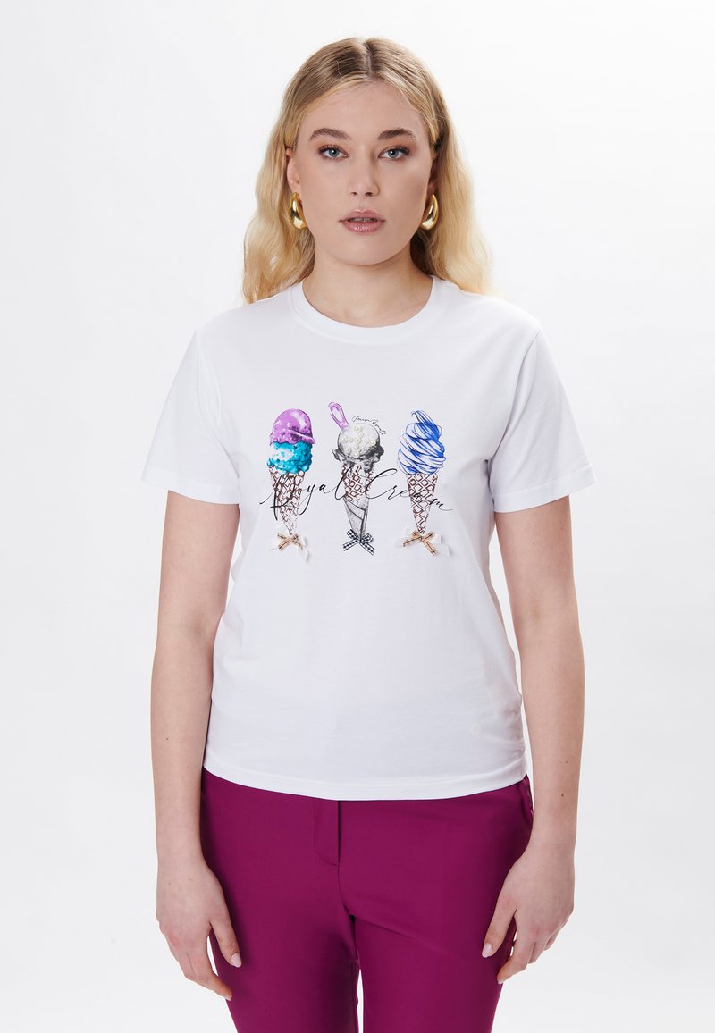 Hvid t-shirt med et farverigt isvaffel-graphic: lilla, blå og pink vafler med teksturerede kugler. Designet inkluderer en detaljeret skråskrift.