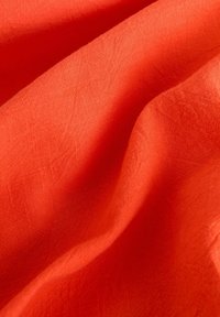 Struktuurne oranž kangas, millel on sile pind, peeneid kortse ja ere, ühtlane värvitoon. Ideaalne erinevate kangaste rakenduste jaoks.