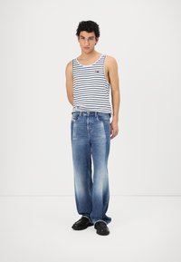 Gestreept tanktop in wit en marineblauw; losse blauwe denim jeans met vervaagde textuur; zwarte schoenen. Eenvoudig, casual outfitontwerp.