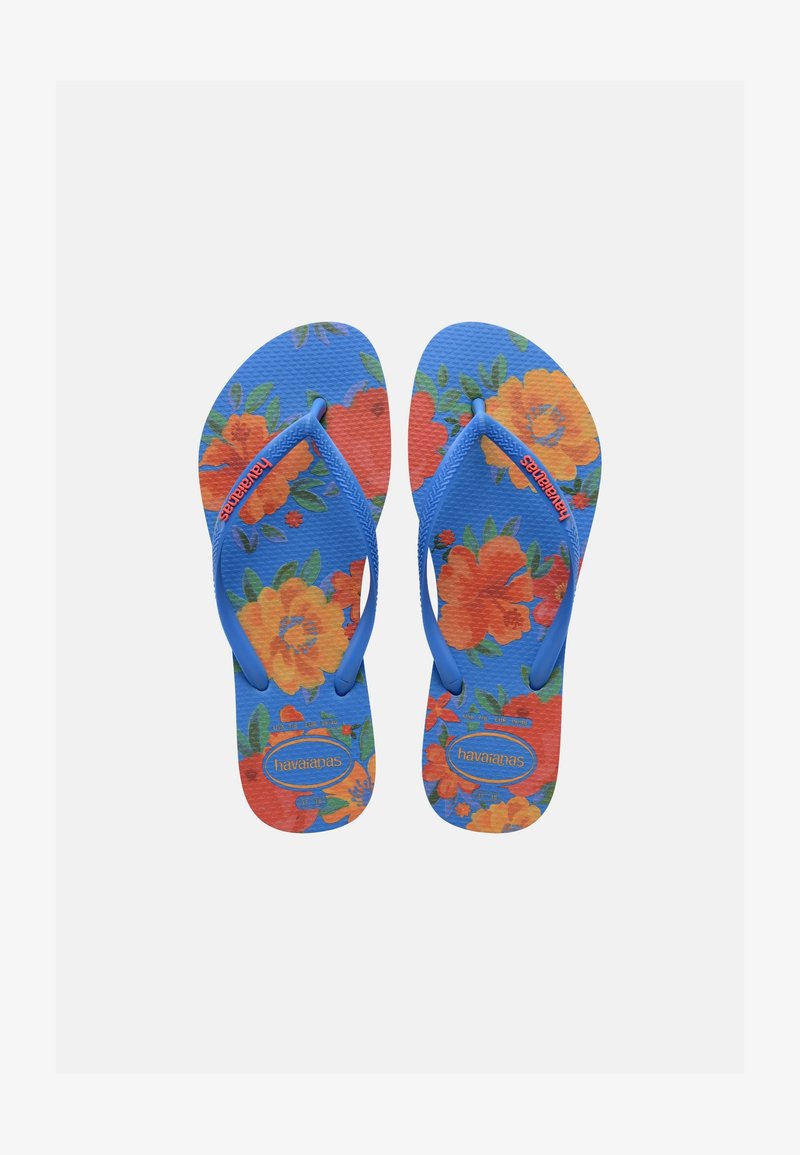 Kék flip-flop papucsok narancssárga és sárga virágmintákkal, kék pántokkal, melyeken narancssárga "Havaianas" márkanév olvasható.