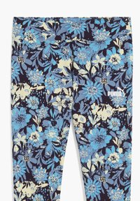 Bloemenleggings met een marineblauwe achtergrond en blauwe en crèmekleurige bloemen. Gemaakt van rekbare stof met een fitted ontwerp. Logo in het wit.