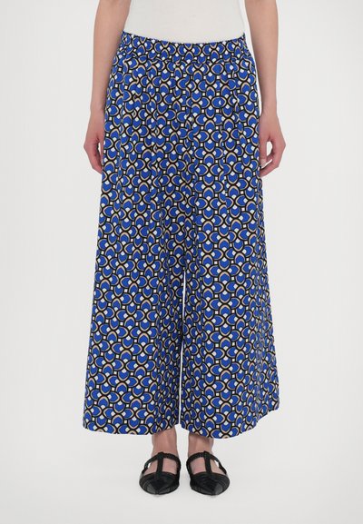 Pantaloni larghi blu con un motivo geometrico in bianco e beige, dotati di una cintura elastica e di una texture morbida e liscia.