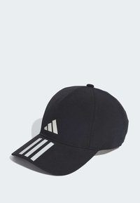 Gorra negra de tela con un diseño estructurado. Presenta tres rayas blancas y un logo en la parte frontal. Visera curvada y parte trasera ajustable.