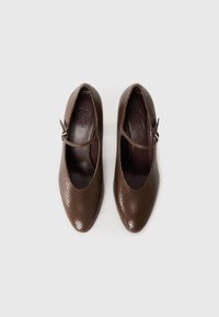 Bruine leren schoenen met een gestructureerd slangenpatroon, ronde neus en een dunne enkelband. Interieur is donkerbruin en voorzien van een merklogo.