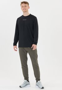 Zwarte lange mouwen shirt met "ENDURANCE" logo; olijfgroene strakke broek; grijze en witte sportschoenen; minimalistisch ontwerp, gladde stoftexturen.