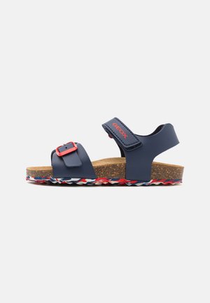 Sandali sintetici blu navy con fibbia rossa, soletta in sughero e suola intrecciata multicolore. Presentano due cinturini regolabili per un maggiore supporto.