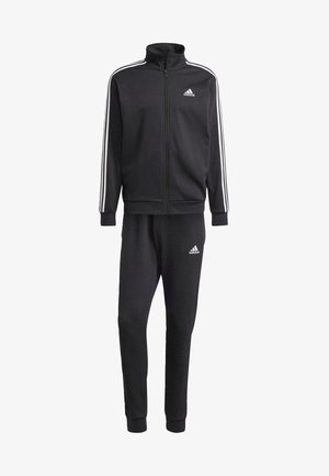 Survêtement Adidas noir en tissu doux, comprenant une veste zippée avec des rayures blanches aux épaules et un pantalon assorti avec des poignets et un logo.