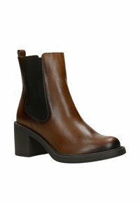 Hnědá kožená kotníková bota s blokovým podpatkem, černým elastickým bočním panelem a poutkem na zadní straně, navržena pro ženy.