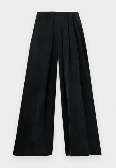 Pantaloni a gamba larga in tessuto verde scuro, con pieghe in vita. Texture liscia con una silhouette fluida. Nessun hardware o motivo visibile.