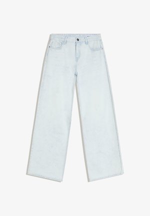 Blugi largi de culoare albastru deschis, cu nasturi și fermoar în față, bucle pentru curea și stil cu cinci buzunare, așezați pe o suprafață albă.