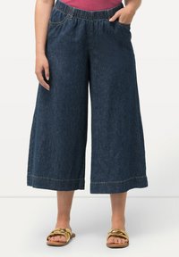 Tmavě modré denimové culottes s elastickým pasem a bočními kapsami, s širokým střihem nohavic a dvojitým švem na lemu.