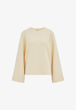 Beżowa bluza z długim rękawem o szerokich rękawach, z okrągłym dekoltem i subtelnym, małym haftowanym logo na górnej lewej stronie klatki piersiowej.