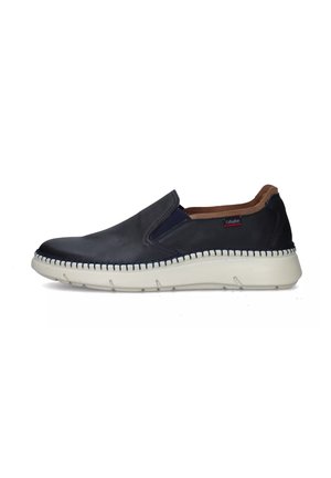 Scarpa slip-on in pelle blu navy con suola in gomma bianca, cuciture a contrasto lungo il lato e un piccolo logo sulla parte superiore. Interno morbido.