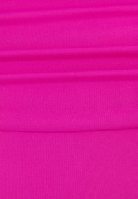Fuchsia stof met een gladde textuur, met een geribbelpatroon. Het materiaal lijkt rekbaar en wordt in plooien getoond.