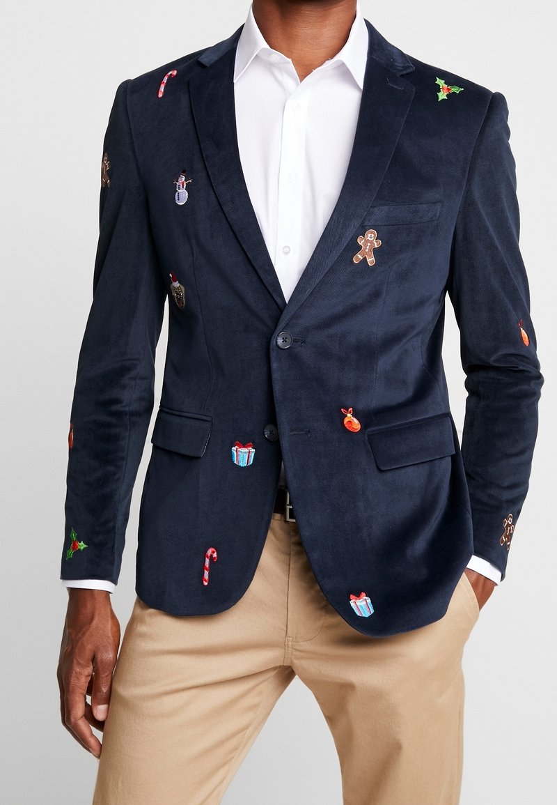 Granatowy żakiet z korduroyu z kolorowym haftem w tematyce świątecznej, w tym cukrowe laski, pierniczki i prezenty.