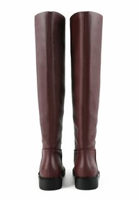 Burgundy leather over-the-knee boots with a smooth texture, flat black soles, and a clean vertical seam at the back for a fitted look.