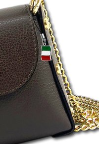 Brown leather handbag with gold chain strap and small pendant of the Italian flag attached to the zipper pull.