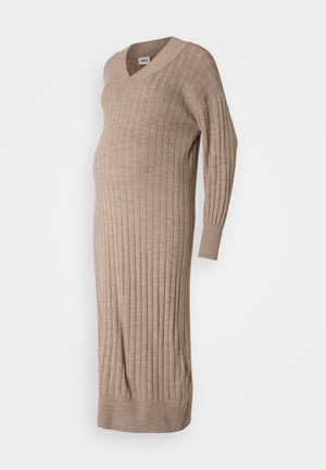Pletené tehotenské šaty béžovej farby s výstrihom do V, dlhými rukávmi, rebrovanou textúrou a voľným strihom navrhnutým pre pohodlie počas tehotenstva.