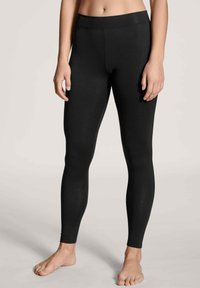 Zwarte leggings van een rekbare, gladde stof, met een hoge tailleband en een aansluitende pasvorm, die tot aan de enkels reiken zonder naden.