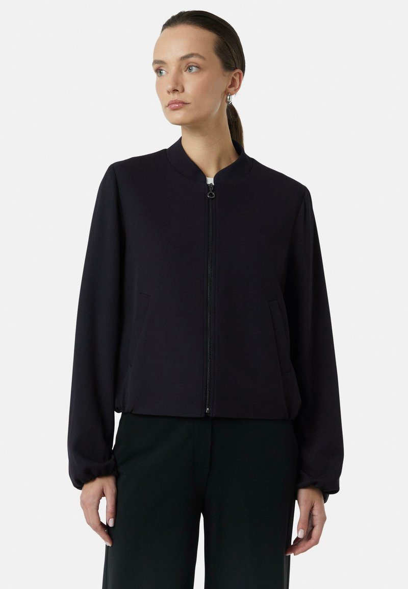 Zwarte cropped bomberjack met hoge kraag, ritssluiting aan de voorkant, zijzakken en taps toelopende mouwen van gladde stof. Eenvoudig, minimalistisch ontwerp.