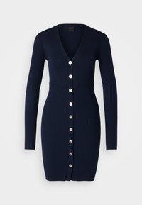 Marineblauwe geribbelde cardigan jurk met lange mouwen, V-hals en zilverkleurige knopen aan de voorkant. Een getailleerde taille en gedetailleerde textuur.
