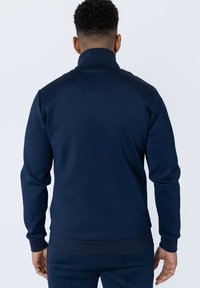  pulover navy cu guler înalt, mâneci lungi și croi slim. Prezintă manșete și tiv ribbate, textură netedă și fără logo-uri sau modele vizibile.