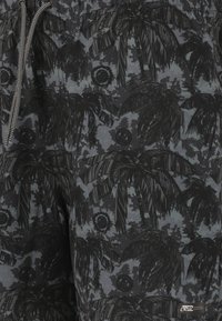 Zwarte zwemshorts met een grijs camouflagepatroon met palmbomen en cirkelvormige accenten, elastische tailleband met een trekkoord.