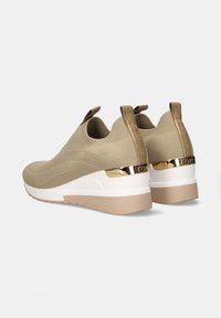 Zapatillas de punto beige con diseño slip-on, tacón acentuado en dorado y media suela blanca, con un acabado texturizado y lengüetas de agarre.